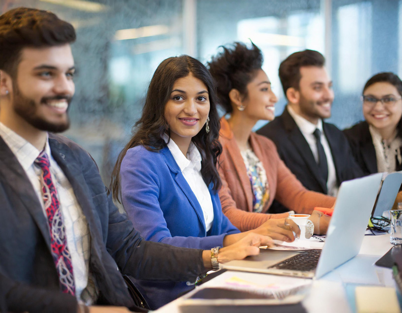 Diverse group of business professionals collaborating at a strategic innovation group meeting in a modern office setting.